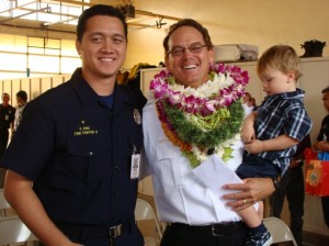 New battalion chief James â€œKimoâ€ Kino is congratulated by his son, Maui Fire Fighter II Kaulana Kino, and grandson Hamilton Kino, age 2.  Photo by Wendy Osher.