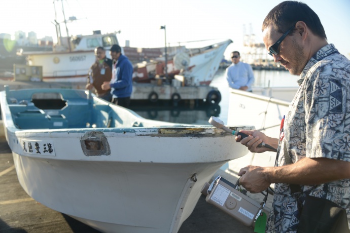 Joshua Marvit, State of Hawaii Dept. of Health, tests a 16 foot skiff for radiation after the vessel was salvaged by the crew of the F/V Zephyr approximately 800 miles north of Honolulu, Oct. 5, 2012. The skiff was confirmed to have been debris from the 2011 Japan Tsunami by the Japanese Consulate, after they contacted the owners through the Japanese Ministry of Foreign Affairs, and confirmed that they did not seek its return. The Department of Land and Natural Resources and the State of Hawaii Department of Health conducted radiation tests and a search for invasive species as a precautionary measure. U.S. Coast Guard photo by Petty Officer 2nd Class Eric J. Chandler.