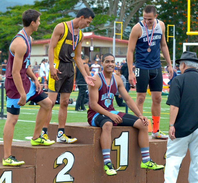 Baldwin high hurdler champion Abraham Reinhardt sits on the awards stand after receiving his gold medal. Teammate Tyler Feiteira (left) and Connor Yap of Kamehameha Maui (right) offer to assist Reinhardt to his feet for picture taking. Photo by Rodney S. Yap.