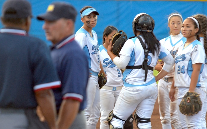 Saint Francis players wait while umpires discuss a ruling Friday at the girls Division II state softball tournament. Photo by Rodney S. Yap.