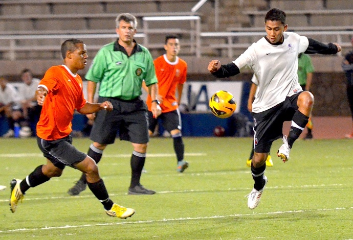 Defender Kainalu Kealoha tries to thwart the attack of forward Lionel Mills during second-half action of the boys Showcase Game Friday at Kanaiaupuni Stadium. Photo by Rodney S. Yap.