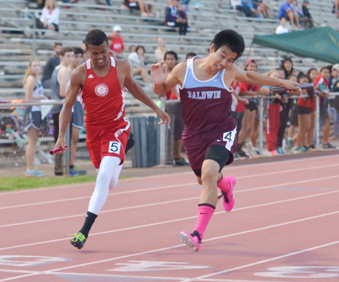 Baldwin's Bailey Kaopuiki (right) nips Lahainaluna's Emerson Liburd at the finish of the boys 4 x 100 relay Friday. The Bears were timed in 45.59 seconds to the Lunas' 45.72 seconds. Photo by Rodney S. Yap.