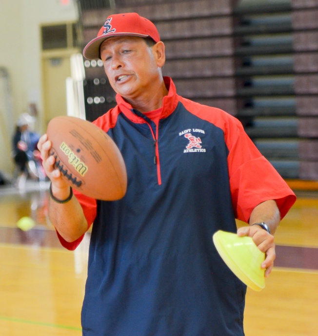 Saint Louis School's assistant coach Vince Passas explains the proper grip to throwing a football Saturday at Baldwin High School Gym, Photo by Rodney S. Yap.