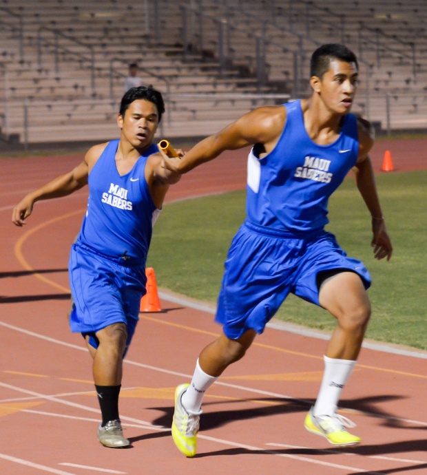 Maui High's Lucas Ibanez hands off the baton to Grayson Biga   in the boys 400-meter weightman's relay Friday. The Sabers won the race with Moana Vainikolo running the first leg and Arven Lacaden running the second leg. Photo by Rodney S. Yap.