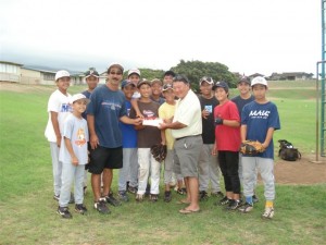 (Former Mayor Alan Arakawa presents a check to the Central East Maui Little League coach, Glenn Yonashiro on Wednesday.  The team did some last minute fundraising prior to leaving for this week's tournament) Courtesy Photo.)