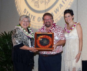 David Fisher (center) receives the Mayor's Community Service Award from Mayor Charmaine Tavares (L) and Economic Development Coordinator Deidre Tegarden (R). Fisher is among the instructors scheduled to speak during the January County of Maui Brown Bags workshops.  Photo by: Sheryl Saphore Photography.