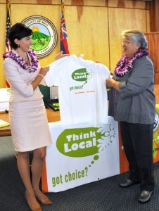Mayor Charmaine Tavares looks at a promotional t-shirt displayed by Economic Development Coordinator Deidre Tegarden (left).