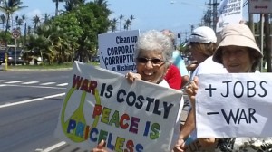 An estimated 25 to 30 people showed up for a sign waving rally fronting the Old Kahului Shopping Center on Maui Sunday afternoon.  Photo by Wendy Osher.