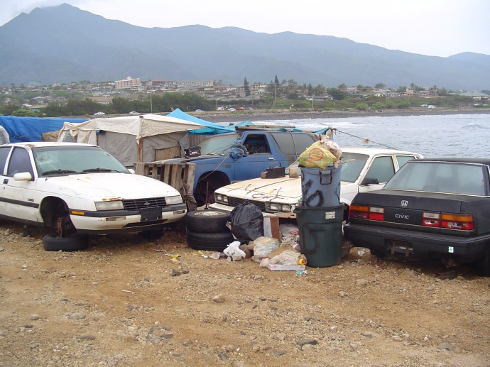 Homeless parked at Kahului Harbor on Maui.  File photo by Wendy Osher, March 2006. The camp was cleared during a subsequent sweep of the area.  Several tent shelters have gone up since then along the shoreline of the harbor in the naupaka bushes. 