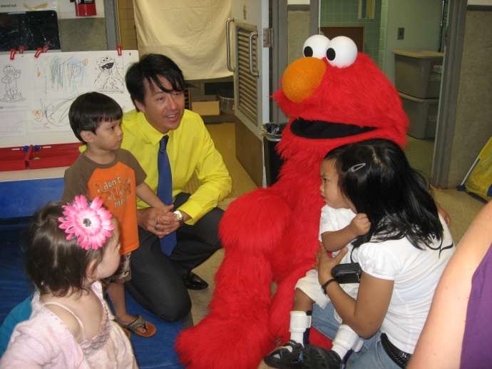 Executive Director Dean Wong and some clients visit with Elmo. Courtesy photo