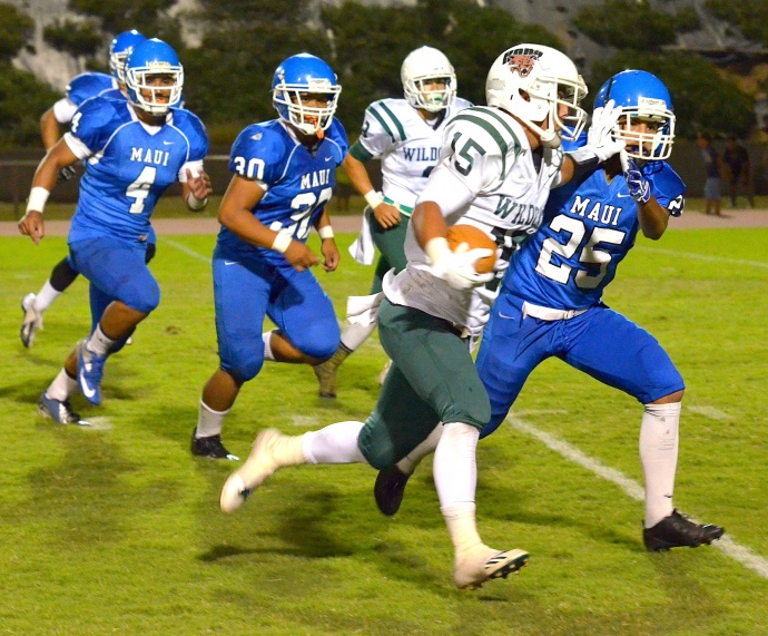 Maui High's Justin Carvalho takes a stiff arm to the face as he tries to tackle Konawaena's Chase Takaki Saturday at War Memorial Stadium. Photo by Rodney S. Yap.