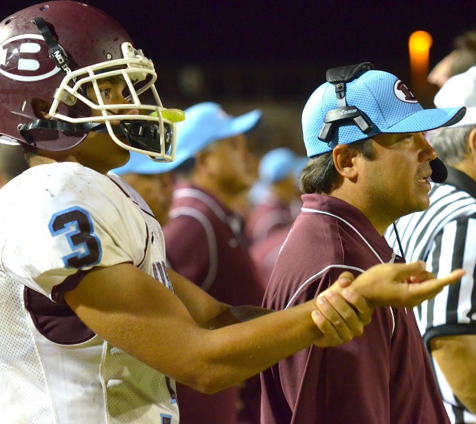 Baldwin offensive coordinator Dave Carino (right) and starting quarterback Jeremiah Badillo (left) signal the play to backup signal-caller Josiah Maglente-Tonu. Photo by Rodney S. Yap.
