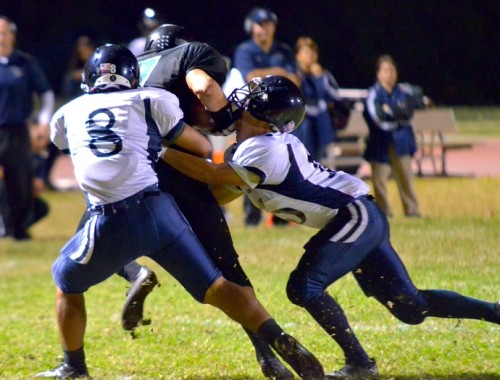 Kamehameha Maui's Austin Kan Hai (5) puts his helmet on King Kekaulike's Charles Apuna after he catches a flat pass from quarterback Ryley Widell. Also helping to bring down Apuna is the Warriors' Michael Kahula. Photo by Rodney S. Yap.