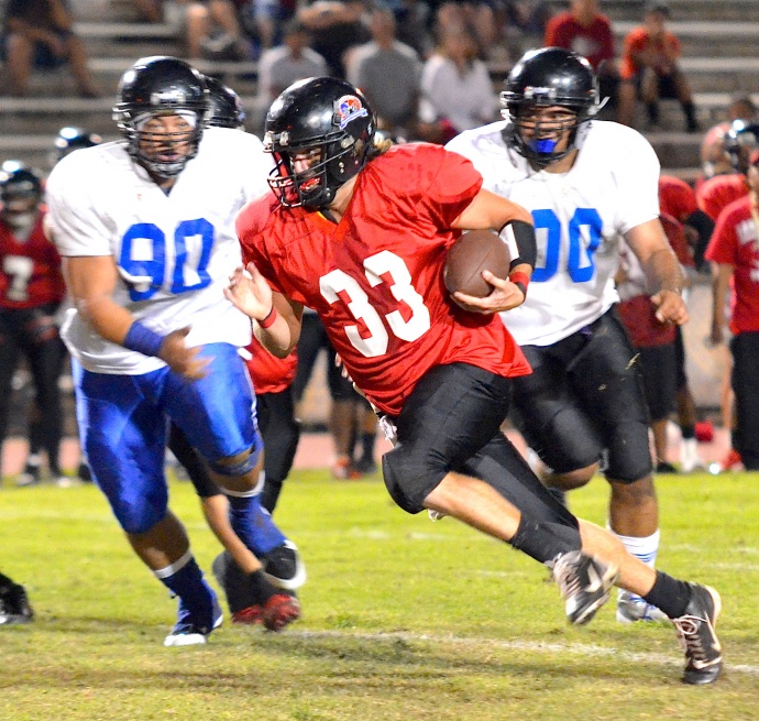 Lahainaluna quarterback Jake Manning (33) kept Maui High's defense guessing late in the game with his feet and his arm. Photo by Rodney S. Yap. 