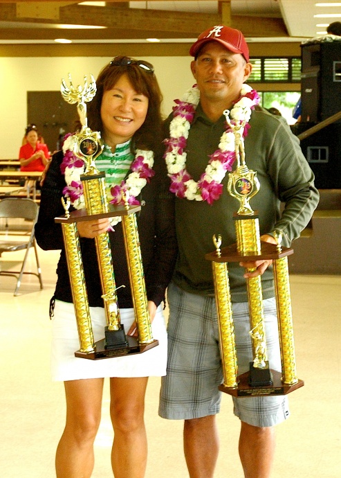 Maui Aloha Golf Classic overall gross champions Mia Hew (left) and Vernon Patao hold up their championship hardware for winning the women's and men's divisions, respectfully. Photo courtesy of Gail Tanaka.
