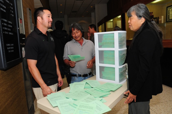 Kurt Yamamura, an HC&S employee; Warren Watanabe, from the Maui County Farm Bureau; and Mae Nakahata, an HC&S agronomist were among those in attendance at the committee hearing on Tuesday. The green cards shown are petitions signed by residents in opposition to the bill.