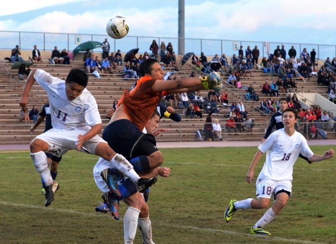 Kamehameha Maui goalie Keola Paredes ties to punch this ball, which was cleared from behind by sweeper Kailoa Akoi. Baldwin's Nash Wuthrich (behind Paredes) and Jaren Ariyoshi (11) supply the offensive pressure. Photo by Rodney S. Yap.