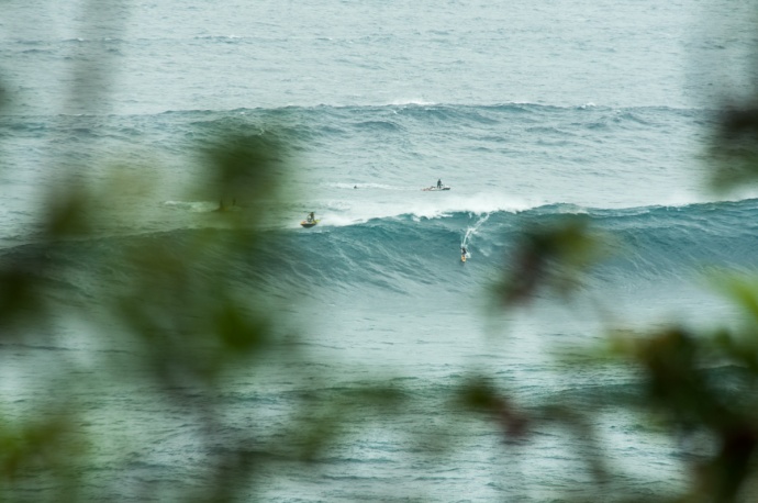 Unknown surfer tows into a massive set at Peahi, Jaws and nearly escapes the heavy lip. Photo by Riley Yap. 
