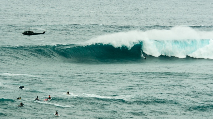 Unknown surfer tows into a massive set at Peahi, Jaws and nearly escapes the heavy lip. Photo by Riley Yap. 