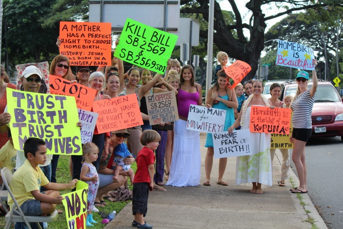 Home birth supporters on Maui carry signs in opposition to a bill before the Senate that seeks to establish licensing requirements and other restrictions on the practice.  The demonstration was held on the lawn fronting the state building in Wailuku. Photo by Wendy Osher.