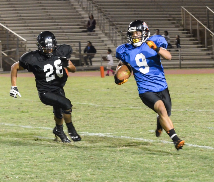 Maui High's Kaiana Camvel (9) finds running room as a King Kekaulike defensive back gives chase. Photo by Rodney S. Yap.