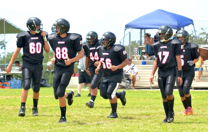 Members of the Kihei Waveriders run onto the field Saturday. Photo by Rodney S. Yap.