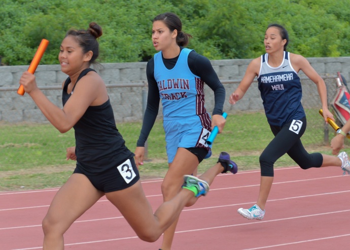 Anchor runners in the girls 4 x 100 relay take off through the final exchange zone after grabbing their batons. Photo by Rodney S. Yap. 