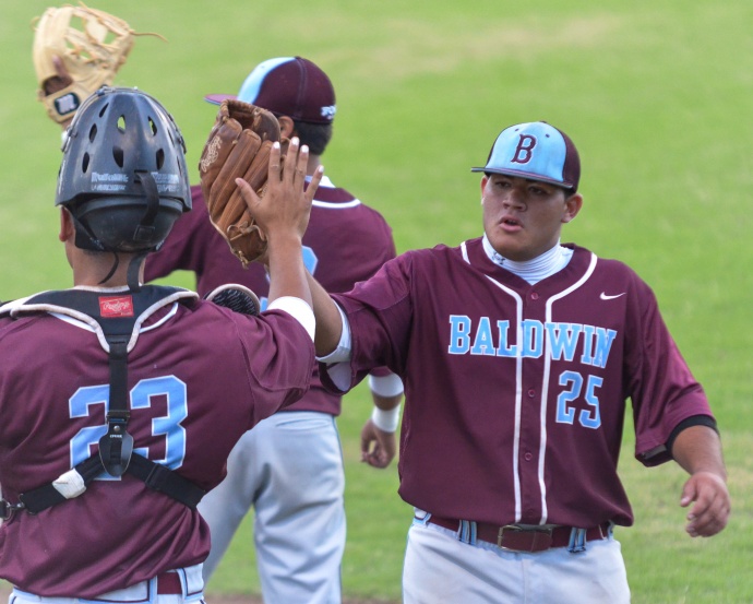 Baldwin battery mates, pitcher Noah Apolo (25) and catcher Makana Victorine (23) high five in between innings Wednesday at Maehara Stadium. Photo by Rodney S, Yap.