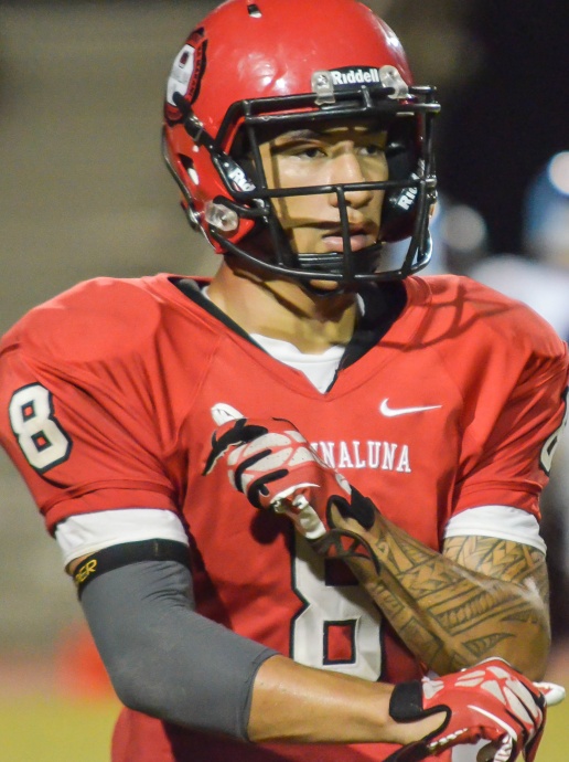 Lahainaluna quarterback Makoa Sione Filikitonga-Lukea takes off his defensive gloves before switching  to offense against Baldwin last Saturday. Photo by Rodney S. Yap.  