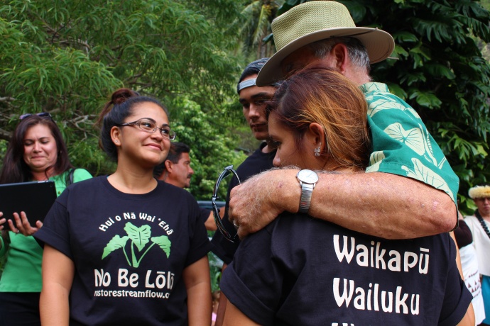 John Duey hugs family members in quiet celebration above the newly released water flow at Kepaniwai. Photo by Wendy Osher.