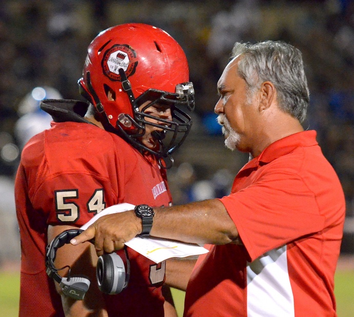 Lahainaluna co-head coach Bobby Watson talks with captain Connor Mowat during a recent game at War Memorial Stadium. Photo by Rodney S. Yap.