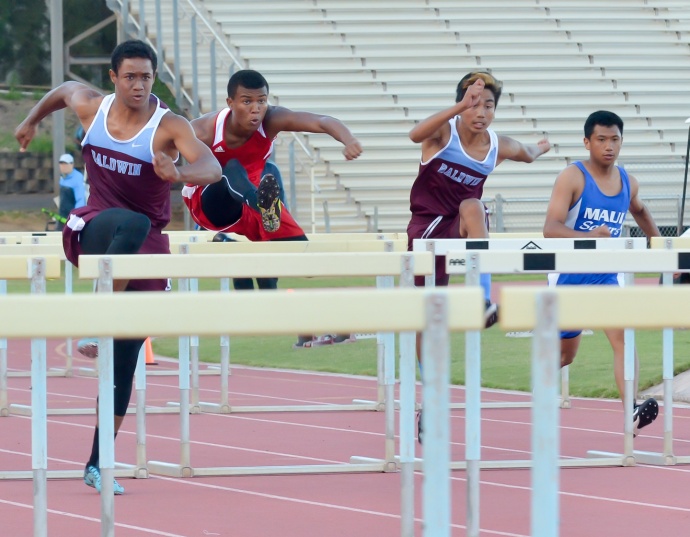 Baldwin's La'akea Kahoohanohano-Davis takes a solid lead over Lahainaluna's Emerson Liburd. But the Lunas' hurdler caught Kahoohanohano-Davis midway through the 110-meter race en route to recording his fastest time ever in 14.57 seconds. Photo by Rodney S. Yap.