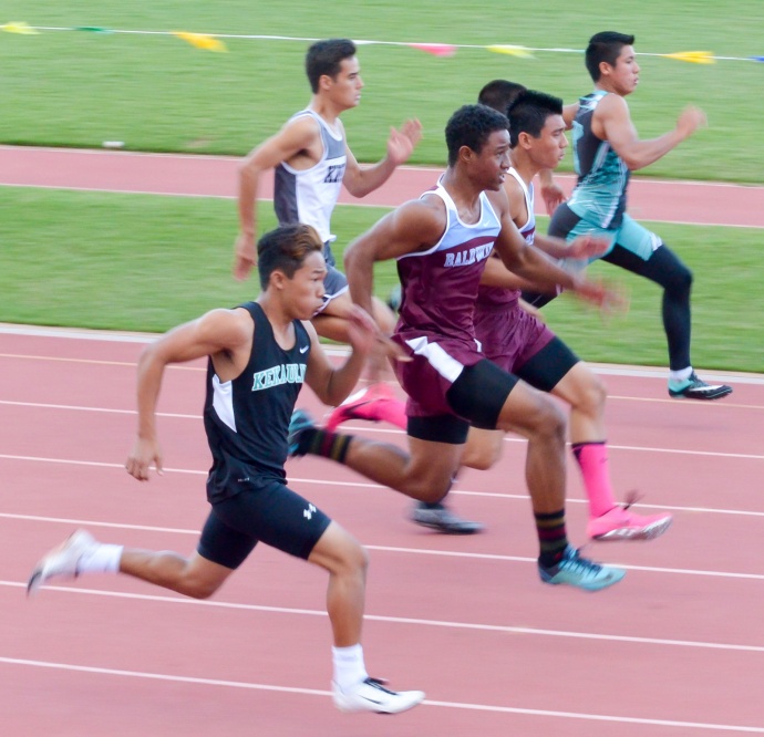 Baldwin's Bailey Kaopuiki (pink socks) won the boys 100-meter dash, but not until he broke away from the pack after suffering a slow start. Photo by Rodney S. Yap.