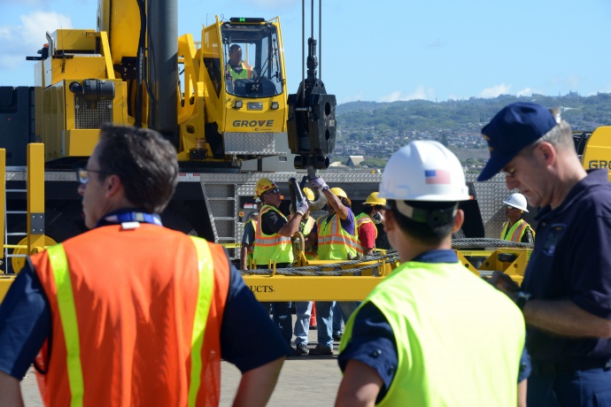 Coast Guard crewmembers and industry personnel observe crane operations during the Hawaii Alternate Port Concept Full Scale Exercise at Joint Base Pearl Harbor-Hickam, June 5, 2015. The purpose of this exercise is to prepare the State, Navy, Coast Guard and industry response partners for their roles during a major catastrophic event that closes the Port of Honolulu and requires the activation of the Alternate Port in Pearl Harbor. (U.S. Coast Guard photo by Petty Officer 2nd Class Tara Molle)