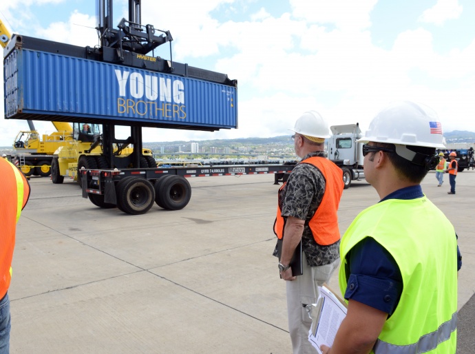 Lt. Cmdr. Bernard Auth, chief of contingency planning and force readiness at Coast Guard Sector Honolulu, observes crane operations during the Hawaii Alternate Port Concept Full Scale Exercise at Joint Base Pearl Harbor-Hickam, June 5, 2015. The purpose of this exercise is to prepare the state, Navy, Coast Guard and industry response partners for their roles during a major catastrophic event that closes the Port of Honolulu and requires the activation of the Alternate Port in Pearl Harbor. (U.S. Coast Guard photo by Petty Officer 2nd Class Tara Molle)