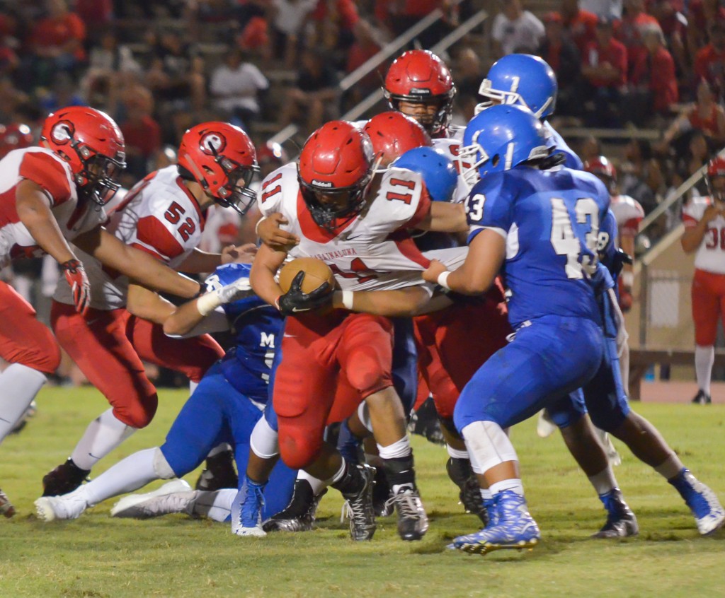 Lahainaluna's Justice Tihada (11) runs for tough yards against the Sabers' defense. Photo by Rodney S. Yap.