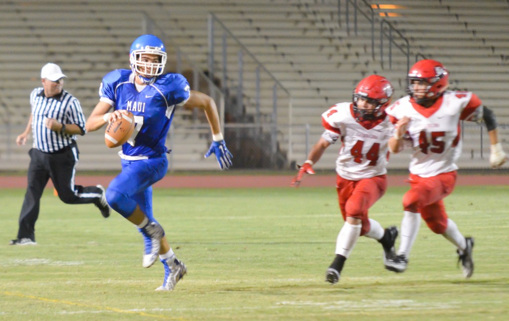 Maui High quarterback Austin Hoe runs from the Lahainaluna pursuit led by Lahainaluna's Ivan Upfold-Pante (44) and Ammon Walters (45). Photo by Rodney S. Yap.