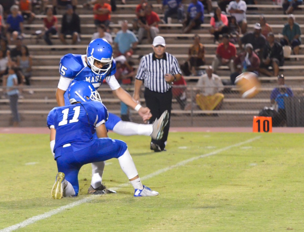 Maui High's Chevee Freitas (15) makes the extra point as teammate Jayden Wilhelm holds. Photo by Rodney S. Yap.