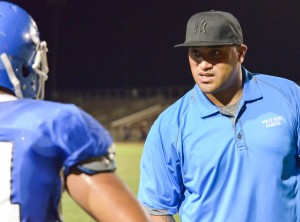 Maui High defensive coordinator Kamaloni Vainikolo talks with one of his defensive players. Photo by Rodney S. Yap.