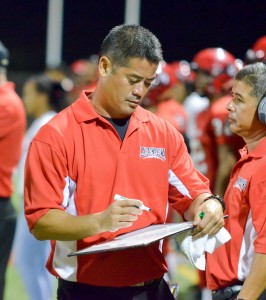 Lahainaluna co-head coach and offensive coordinator Garret Tihada draws up a play during a break in the game Saturday. Photo by Rodney S. Yap.