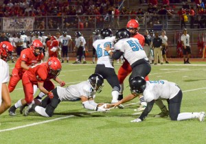 Kekaulike's Kawika Akahi (11) hauls in this loose ball in the backfield. in front of quarterback Cameron Russell. Photo by Rodney S. Yap.
