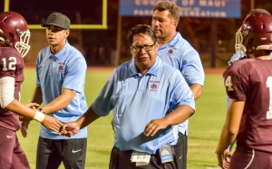 Baldwin head coach Pohai Lee and offensive assistants Lemoa Tua (back) and Colten Quinabo (left) congratulate members of the offensive unit after a Baldwin touchdown Friday. Photo by Rodney S. Yap.