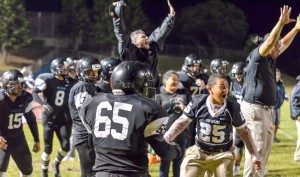 King Kekaulike's coaches and players celebrate a huge catch at the opposite side of the field that helped Na Alii score their first touchdown of the game. Photo by Rodney S. Yap.