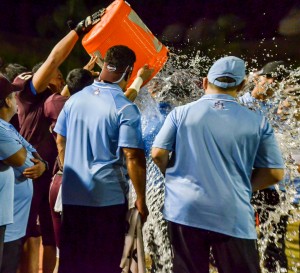 Baldwin head coach Poohai Lee is surrounded by his assistant coaches before getting doused with Gatorade by his players on the sidelines Friday night at War Memorial Stadium. Photo by Rodney S. Yap.