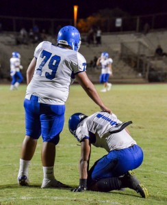 Maui High's Soane Vaohea (1) kneels in frustration following a 99-yard fumble return for a touchdown by Baldwin. Teammate Chance Rodrigues is there for support. Photo by Rodney S. Yap.