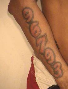 Shaun M. Dennis has the following tattoos: “Gangster holding a gun” on his right chest and “96793” on his right forearm.