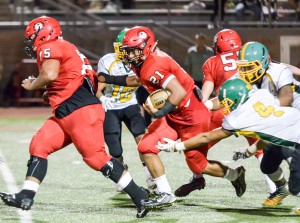 Lahainaluna's Donovan Defang (21) follows the block of teammate Junior Moala (75) up the middle against Kaimuki on Saturday. Photo by Rodney S. Yap.