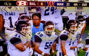 Baldwin breaks the huddle on the sidelines with head coach Pohai Lee and runs in for the final play of the game. Photo from OC16 broadcast.