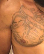 Shaun M. Dennis has the following tattoos: “Gangster holding a gun” on his right chest and “96793” on his right forearm.
