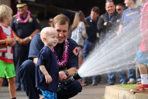 Trucker Dukes shooting water with his dad, firefighter Joshua Dukes outside of the Kahului Fire Station. Photo by Wendy Osher.